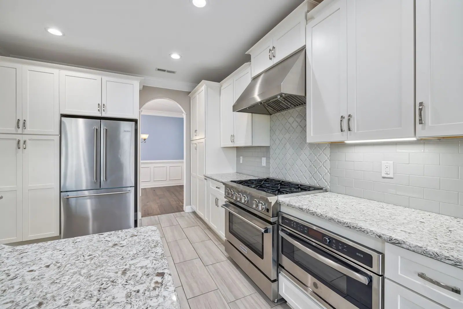 Remodeled kitchen with white shaker cabinets, granite countertops and stainless steel appliances