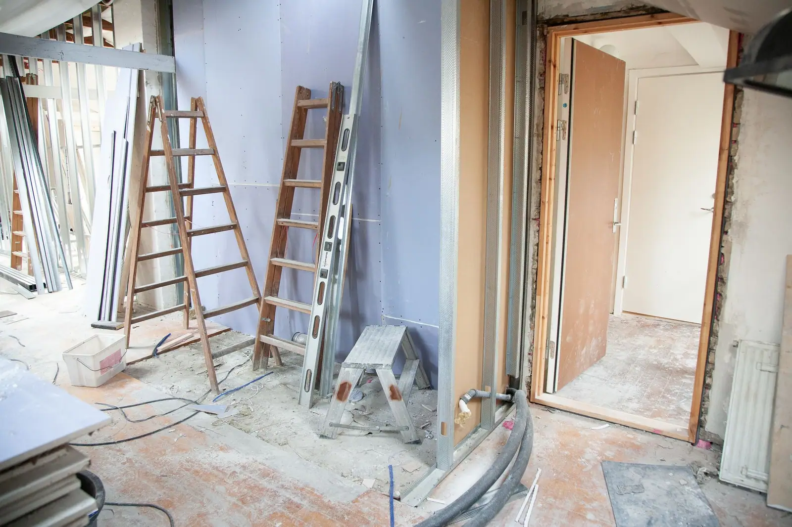 Interior rooms stripped for renovation with ladders and exposed wall framing